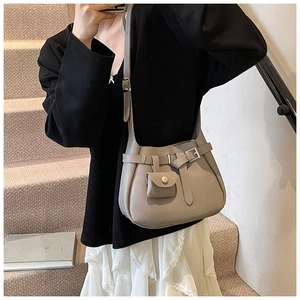 Detail of beige pebbled leather bucket bag with a detachable mini coin purse accessory