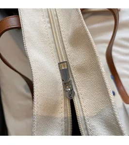 Vue détaillée de la fermeture à glissière en métal argenté sur le sac fourre-tout