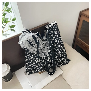 Détail d'un sac cabas floral en toile avec bordures en dentelle et grand nœud blanc