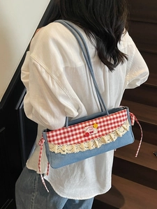 Sac sous le bras en denim bleu avec rabat vichy rouge et dentelle sur mannequin
