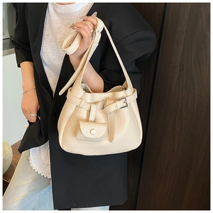 Close-up of cream pebble leather shoulder bag with decorative buckle and small pouch