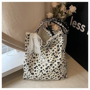 Détail du sac en toile fleurie avec bordure en dentelle marguerite et nœud blanc