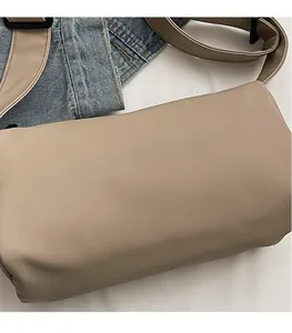Close-up of khaki canvas pillow bag with Moonlersa logo on denim background