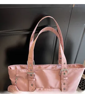Detail view of pink nylon tote bag with adjustable eyelet straps and coin purse