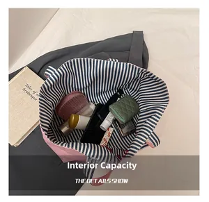 Spacious interior of pink canvas tote showing blue striped lining and daily essentials