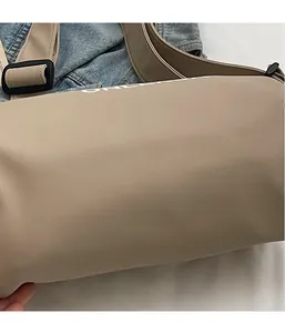 Close-up of khaki nylon pillow bag with MOONLE lettering and black adjustable buckle