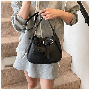 Detail of black lychee grain bucket bag with silver buckle and mini pouch accessory