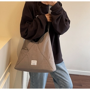 Close-up of canvas tote bag with washed texture and minimalist white logo patch