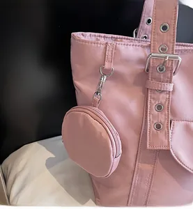 Pink nylon tote bag detail showing detachable round coin purse and metal buckle