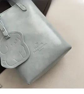 Detail of PANTOR LONDON bucket bag featuring blue leather texture and dog-shaped charm
