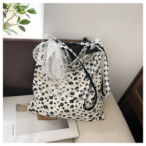 Détail du sac cabas en toile fleurie avec sangle en dentelle marguerite et nœud