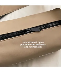Macro detail of glossy black hardware zipper and smooth khaki canvas on the shoulder bag