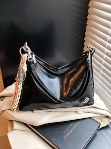 Minimalist black shiny shoulder bag with tassel charm and sleek leather texture