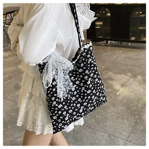 Détail du sac cabas en toile à fleurs avec motifs marguerites et grand nœud en dentelle