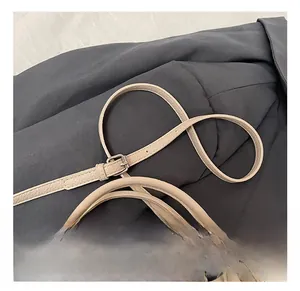 Detail showing adjustable apricot leather shoulder strap with silver buckle on bucket bag