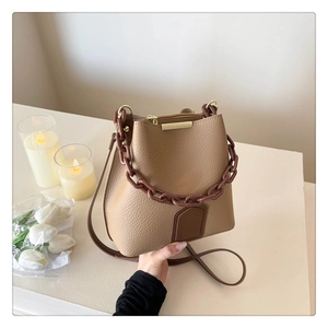 Détail du sac seau kaki en cuir grainé avec poignée chaîne épaisse et bandoulière réglable