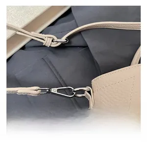 Detail of high-quality metal lobster clasp and lychee pattern leather on beige handbag
