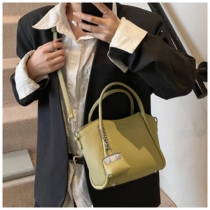 Green lychee pattern bucket bag styled as a crossbody with professional office attire
