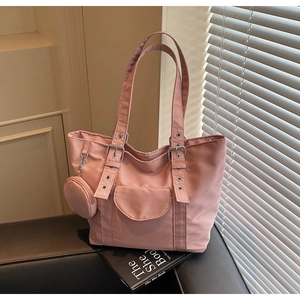 Detailed shot of pink nylon tote bag with metal eyelet straps and small round coin purse