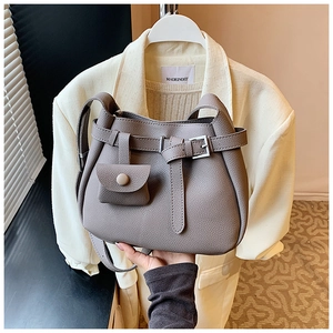 Close-up of grey litchi grain bucket bag with silver buckle and mini pouch detail