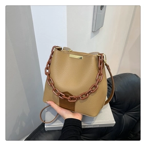 Détail du sac seau kaki avec texture cuir lychee et bandoulière en chaîne résine
