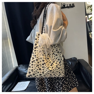 Détail du sac cabas floral en toile avec bordure en dentelle et bandoulière brodée