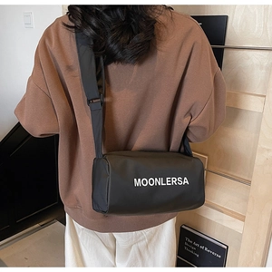 Detail of black canvas Boston bag with wide shoulder strap and MOONLERSA logo