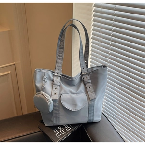 Detail of light blue waterproof tote bag with adjustable silver buckle and coin purse