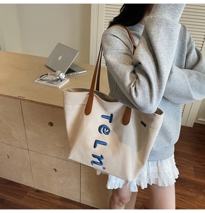 Détail du sac cabas en toile avec broderie 3D bleue et anses en similicuir marron