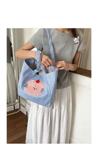 Détail du sac fourre-tout en toile à carreaux bleu clair avec broderie chat rose