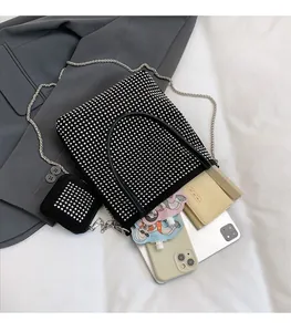 Détail de l'intérieur spacieux d'un sac hobo noir orné de strass avec accessoires