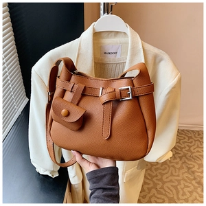 Detailed view of brown lychee texture leather shoulder bag with a mini pouch and buckle