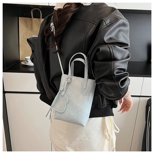 Mini light blue leather tote bag with shoulder strap and side charm detail