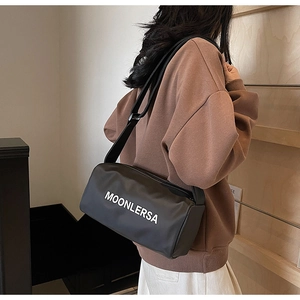 Close-up of black canvas cylinder bag with Moonlersa logo and wide shoulder strap
