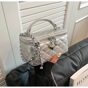 Detail of silver quilted chain bag with heart pendant and metallic leather texture