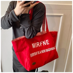 Detail view of the red canvas tote bag interior with striped lining and printed text
