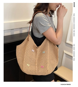 Detailed close-up of woven straw tote bag featuring colorful bows and leather strap