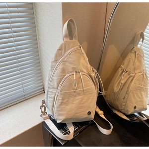 Close-up of beige nylon teardrop backpack with functional multi-pockets and side water bottle pouch