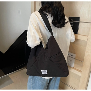 Close-up of black canvas hobo bag showing large capacity and white textile label