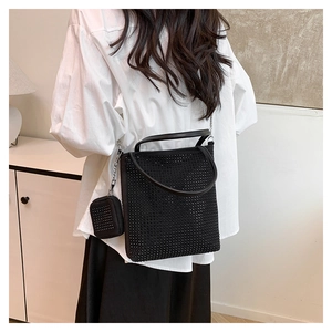 Détail du sac baguette noir orné de strass avec rivets et bandoulière en chaîne argentée