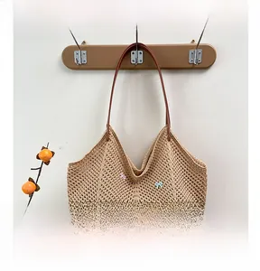 Detail of beige woven tote bag featuring colorful bows and long brown leather handles