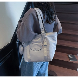 Detail of grey nylon tote bag with small round coin purse and metal buckle strap