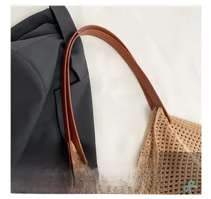 Detail of woven mesh texture with blue bow embroidery and brown leather handle