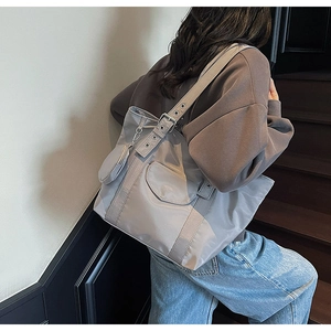 Detail of grey nylon tote bag with round coin purse and adjustable metal eyelet strap