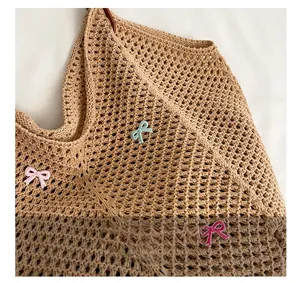 Detailed macro view of khaki crochet knit texture with blue and pink 3D bow accents