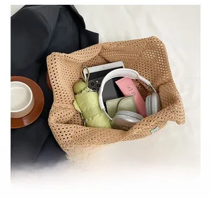 Spacious interior of beige crochet tote bag showing tablet, headphones and daily essentials