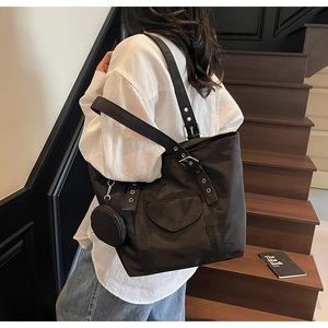 Detail of black nylon tote bag with heart-shaped pocket and round coin purse hanging