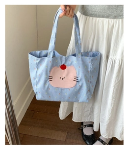 Détail du sac fourre-tout en toile à carreaux bleu clair avec broderie chat rose et cerise