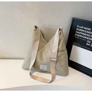 Detail of khaki nylon tote bag showing fabric texture and adjustable wide shoulder strap