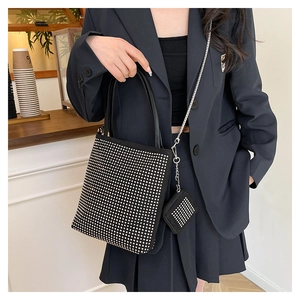 Détail d'un sac à main noir en strass avec paillettes et mini-pochette assortie